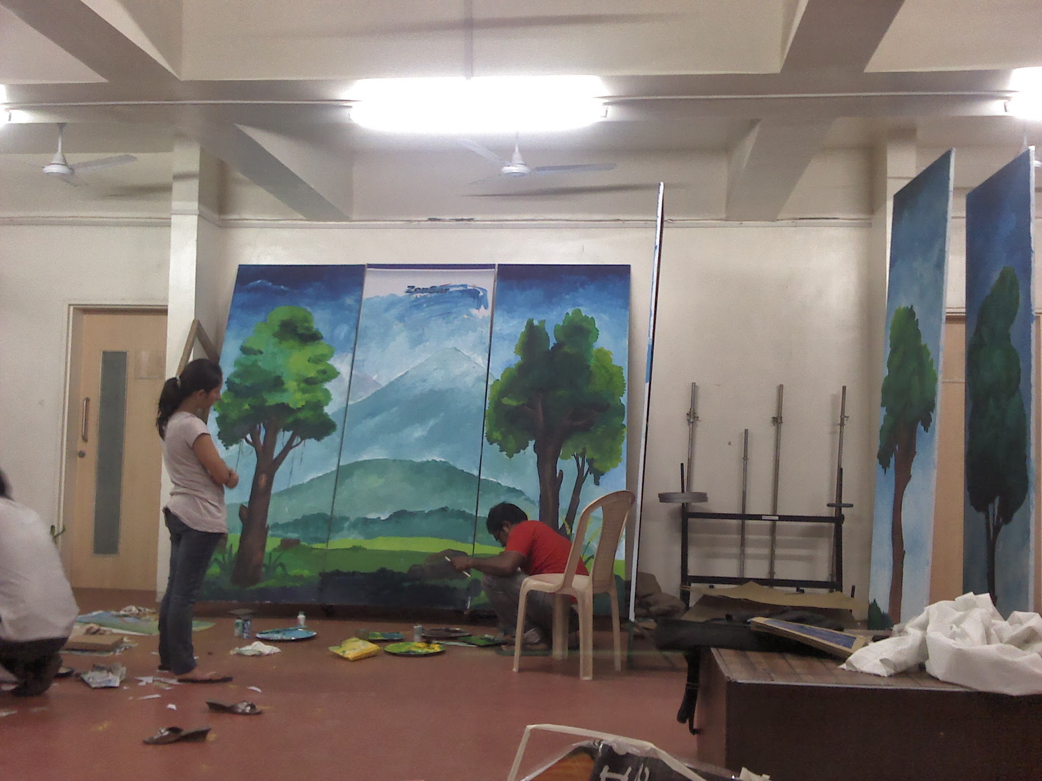 Behind the scenes: set crew painting the mountain and forest backdrop