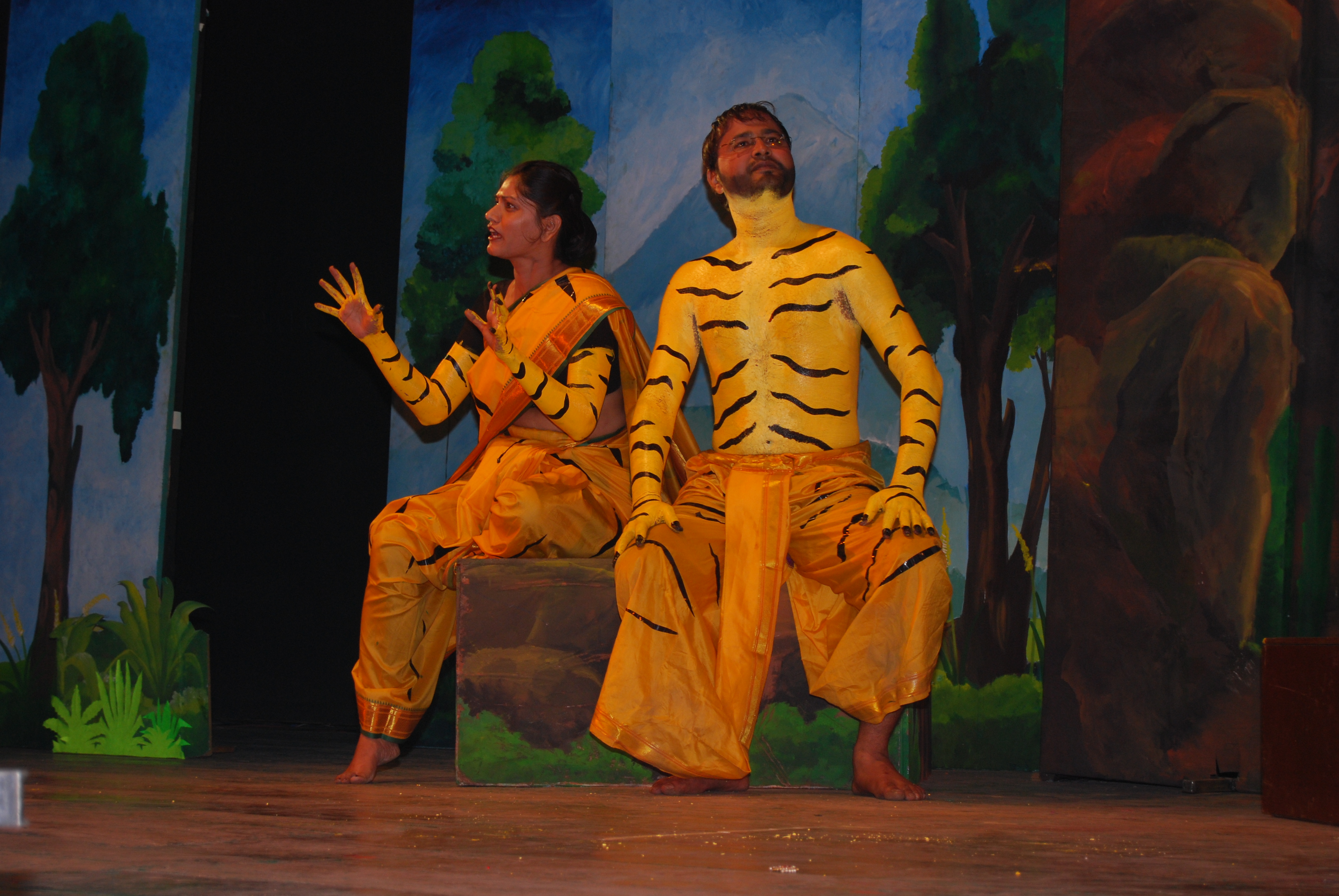 Two actors painted as tigers on stage in mid-performance