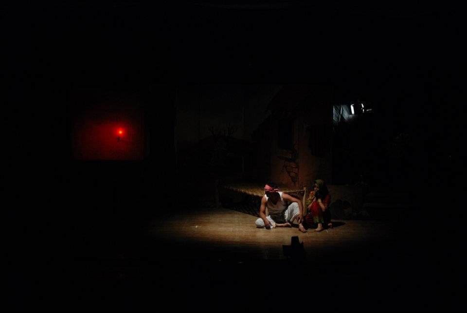 Ensemble of actors in white sheep costumes and masks on stage